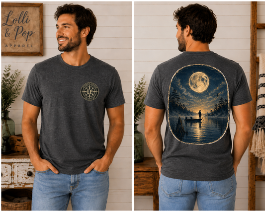 Man wearing the Fisherman's Moon graphic tee featuring a peaceful angler fishing beneath a glowing full moon on a quiet lake.