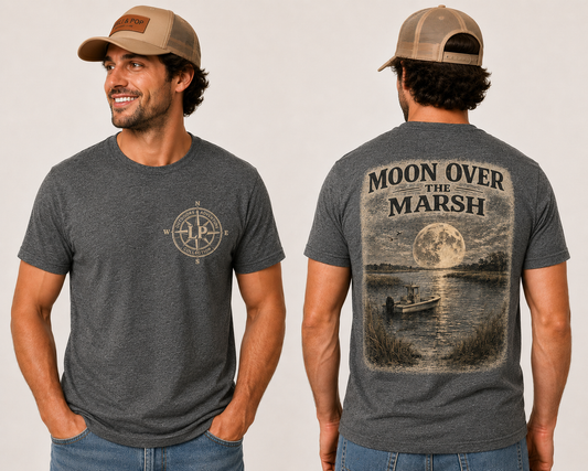 Man wearing the Moon Over the Marsh graphic tee featuring a vintage coastal marsh scene beneath a full moon.