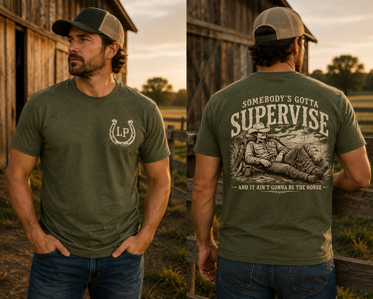 Man wearing the Somebody's Gotta Supervise western graphic tee featuring a relaxed cowboy and horse in a vintage ranch scene.